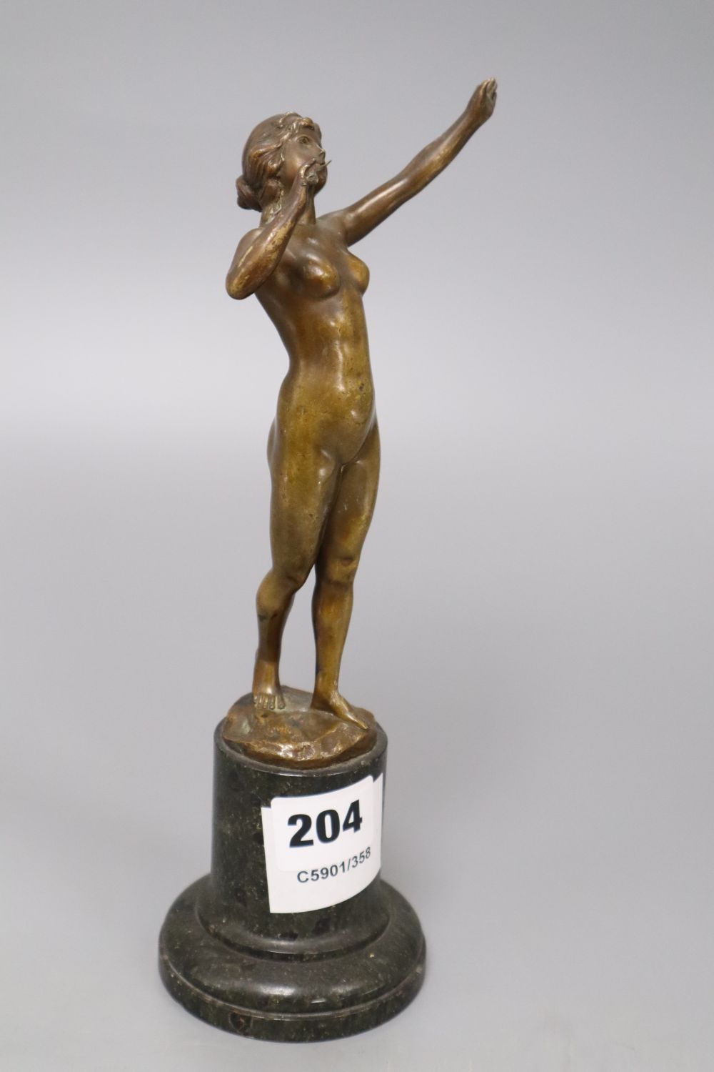 An early 20th century bronze of a nude lady, indistinctly signed, on marble base, overall height 25cm
